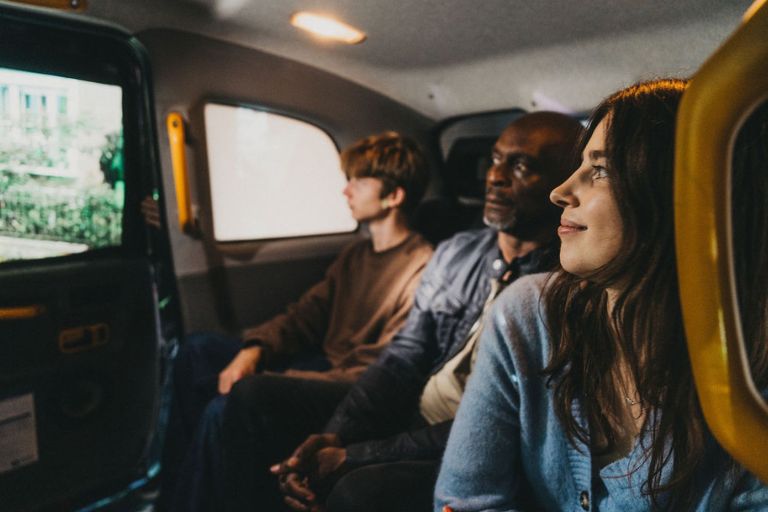 Audience members watch Driving Home from the back of a black cab