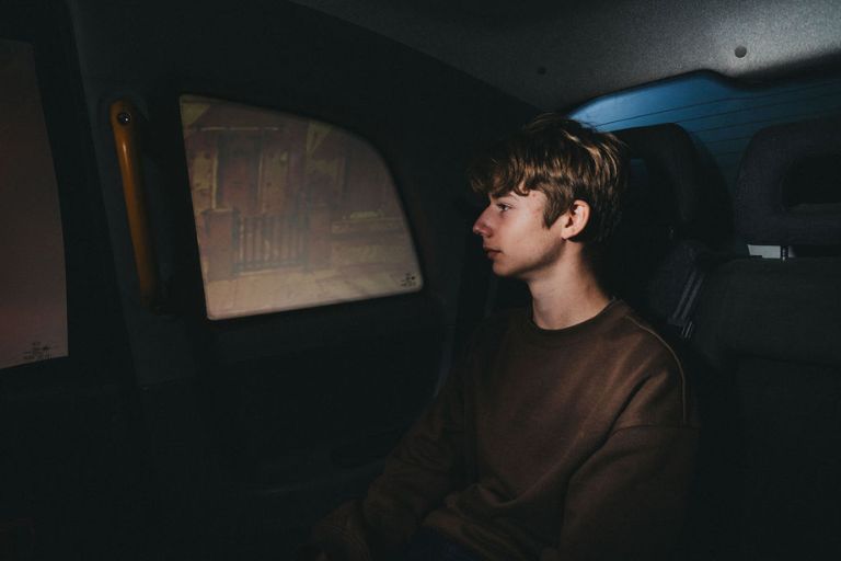 Audience members watch Driving Home from the back of a black cab