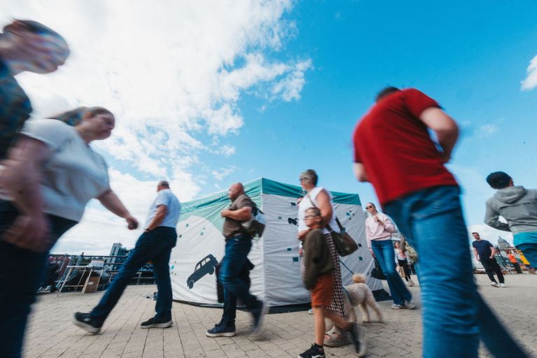 People walking past the Driving Home gazebo on a sunny day